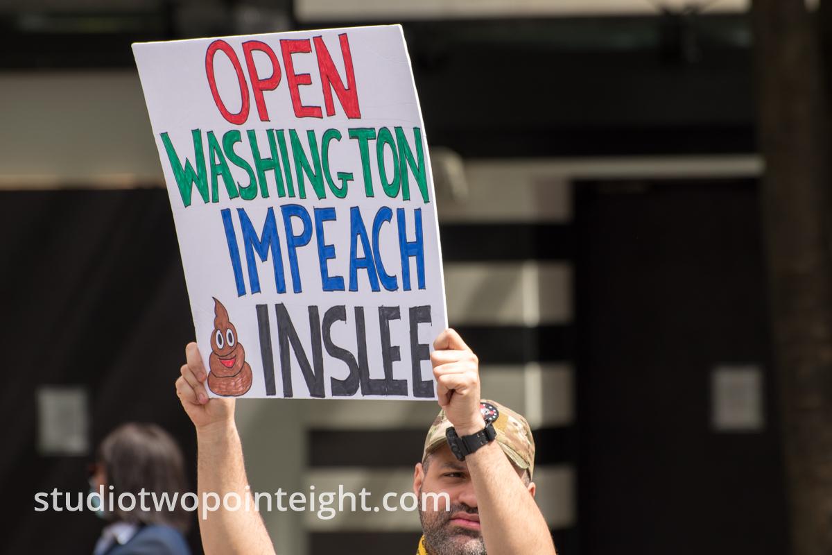 Studio 2.8, May 1, 2020, Seattle May Day End Coronavirus Lockdown Protest, An Attendee Displayed A Large Poster With The Phrase Open Washington Impeach Inslee On It