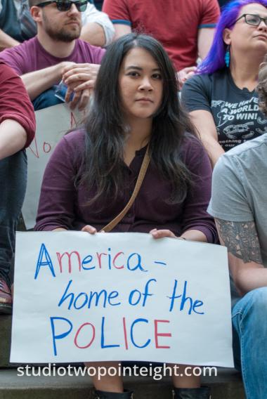 2015 Seattle May Day Immigrant Rally, Woman With American Home Of The Police Poster
