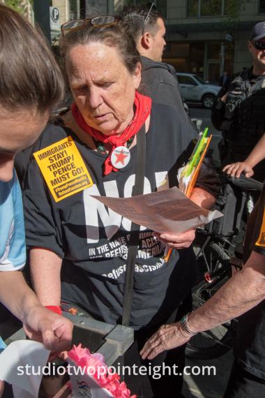 Seattle May 1, 2019 May Day Immigration Rally Woman Passing Out Communist Party Stickers