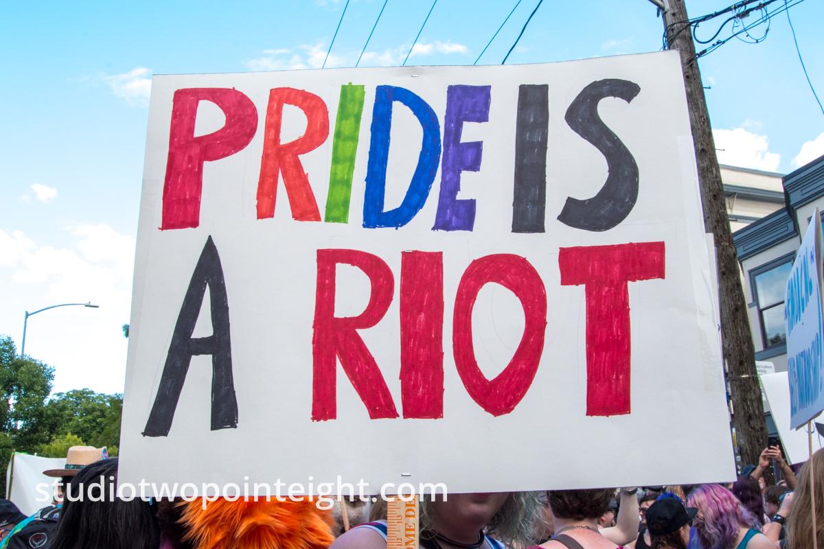 Seattle Trans Pride 2019, An Attendee Held Aloft a Pride Is A Riot Sign